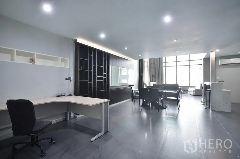 Condominium for rent in Khlong Toei, Bangkok - Spacious work and study corner with desk and shelving within the open-plan living area.