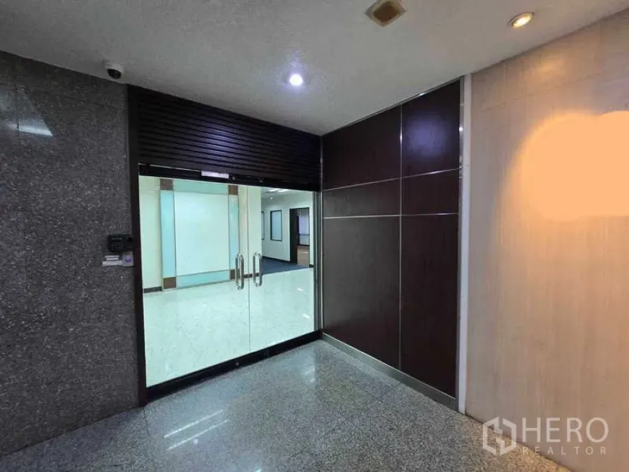 办公空间 出租在Khlong Toei, Bangkok - 空堤区办公楼内的玻璃双开门入口与抛光走廊。