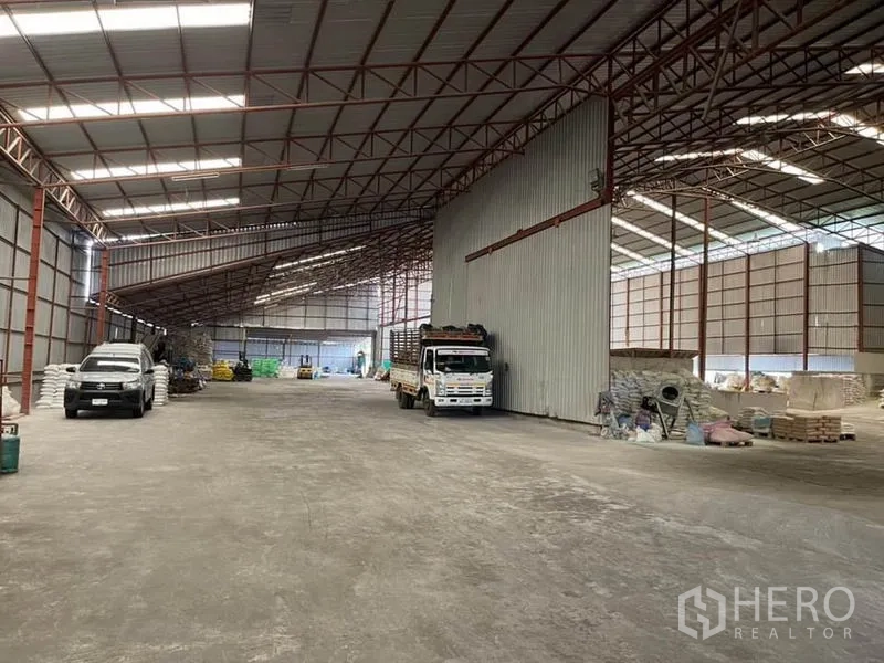 Warehouse for sale in Lam Luk Ka, Pathum Thani - Central bay with a truck parked next to tall corrugated walls and expansive maneuvering space.