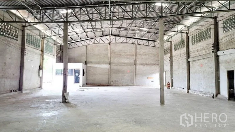 Warehouse for rent in Mueang Samut Sakhon, Samut Sakhon - Clear-span warehouse interior with steel roof trusses and ventilation blocks.