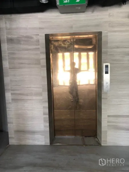 Retail Space for rent in Khlong Toei, Bangkok - Passenger lift with metallic doors in the modern lobby of the Watthana retail building.