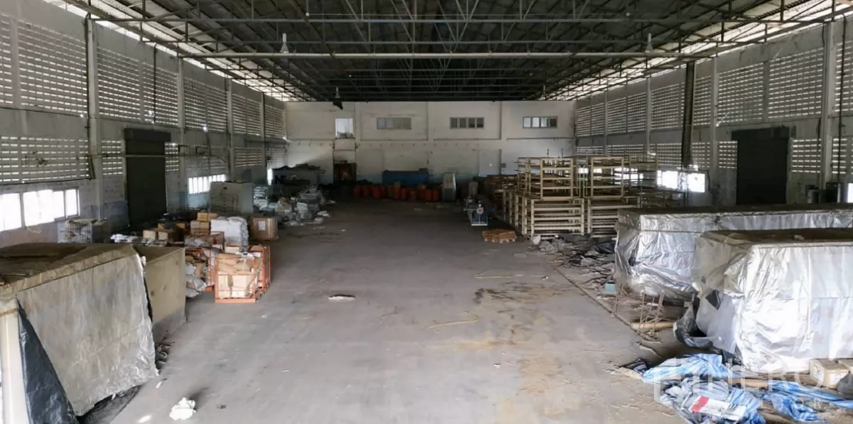 Factory for rent in Bang Pakong, Chachoengsao - Spacious factory hall with high steel truss roof, ventilation blocks, pallets and storage racks.
