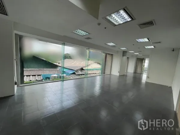 Office Space for rent - Spacious rectangular office area with tiled flooring and fluorescent light panels.