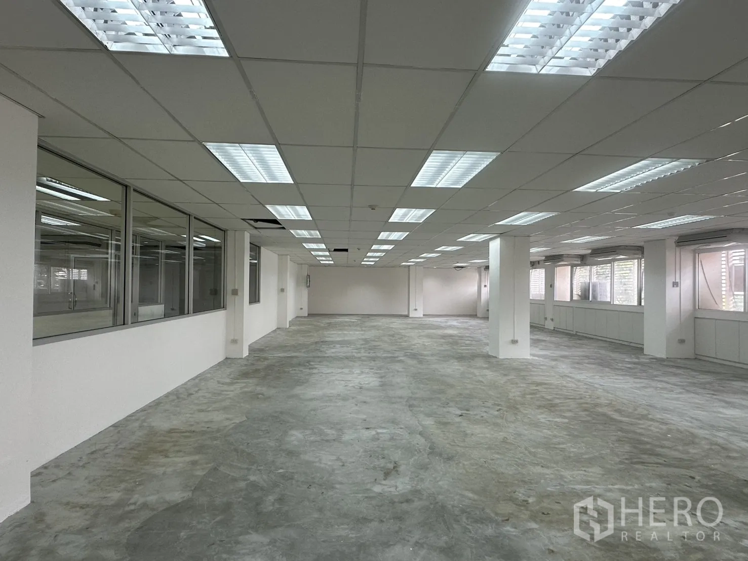Office Space for rent in Pathum Wan, Bangkok - Open workspace beside glass-partitioned rooms and ceiling grid lights.