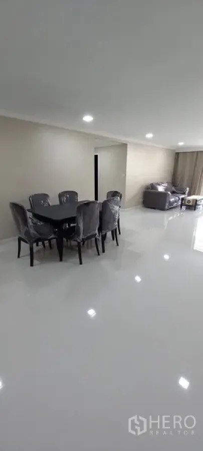 Condominium for rent in Watthana, Bangkok - Spacious open-plan living and dining area with glossy white floors and recessed lighting.
