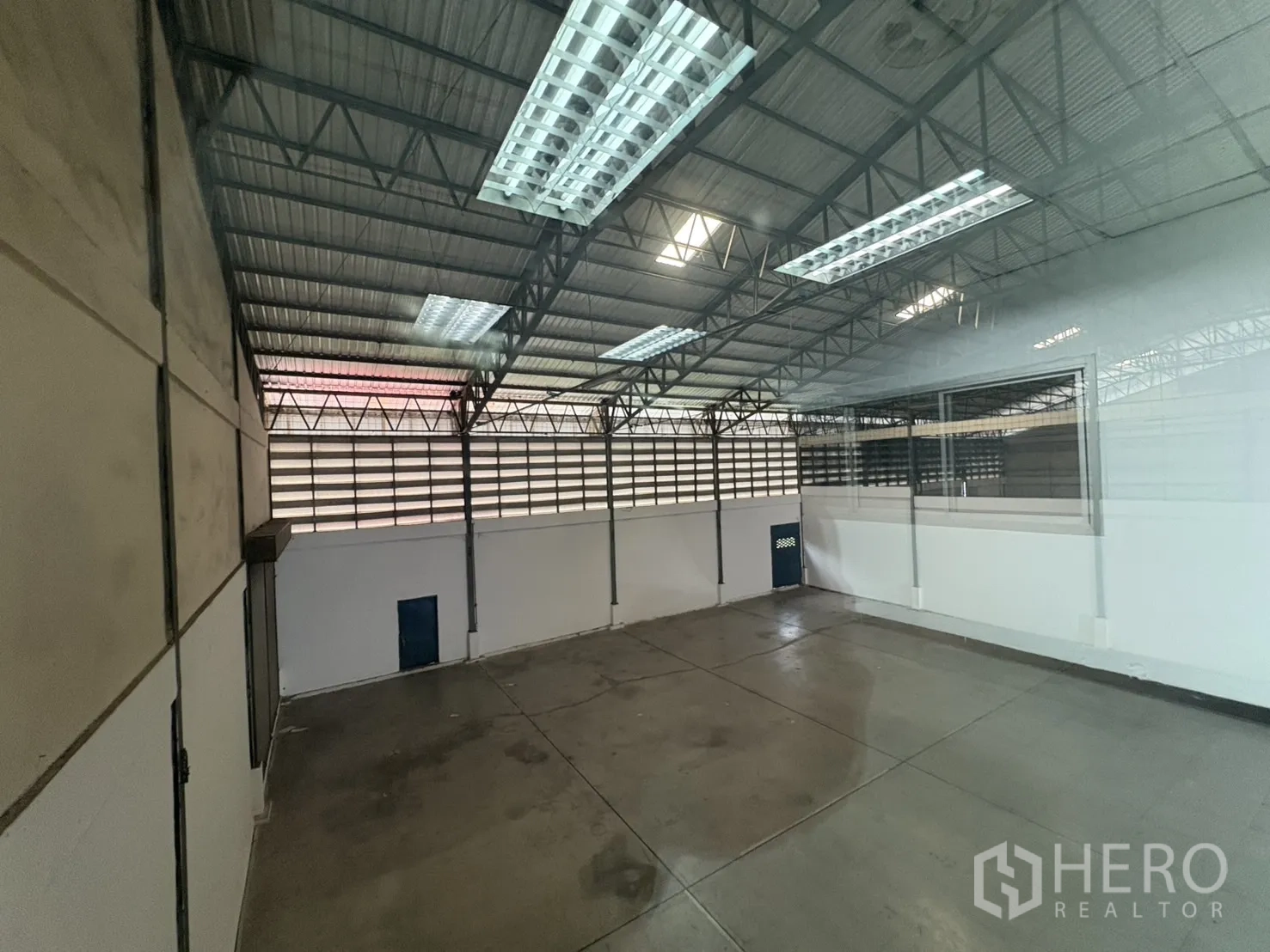 货栈 出租在Bang Phli, Samut Prakan - 从办公室窗户看到的仓库区域，混凝土地面与通风百叶