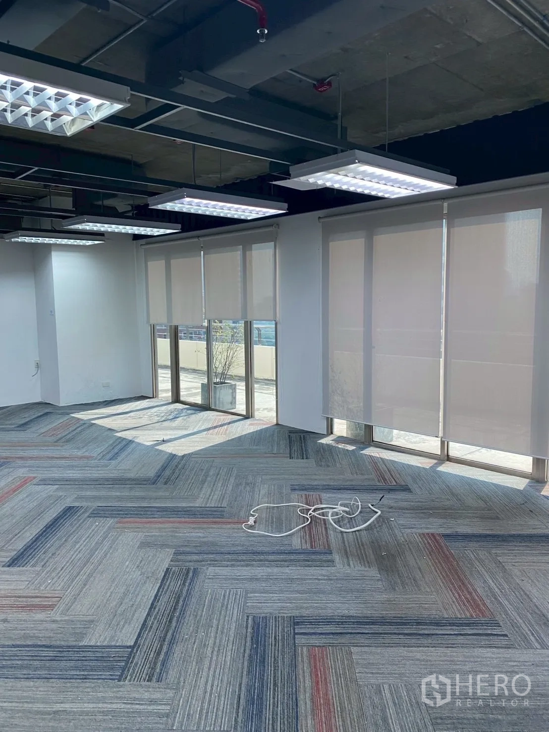 Office Space for rent in Watthana, Bangkok - Bright corner office with large windows and roller blinds.