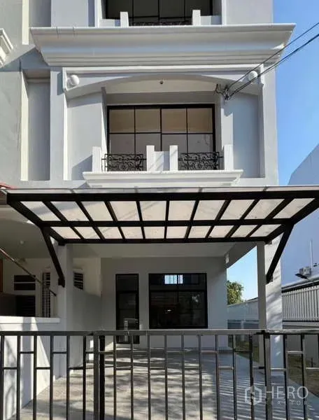 Townhouse for rent or sale in Prawet, Bangkok - Three-storey modern townhouse facade in Prawet with gated carport and balcony.