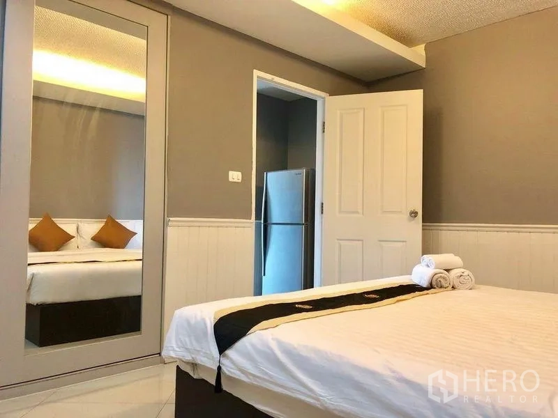 Condominium for rent in Khlong Toei, Bangkok - Master bedroom with mirror wardrobe and neutral décor in Bangkok condo.