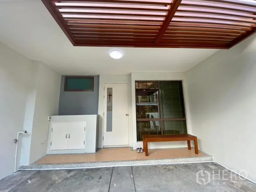 Townhouse for rent in Phra Khanong, Bangkok - Covered front porch and carport with wood slat canopy and bench.
