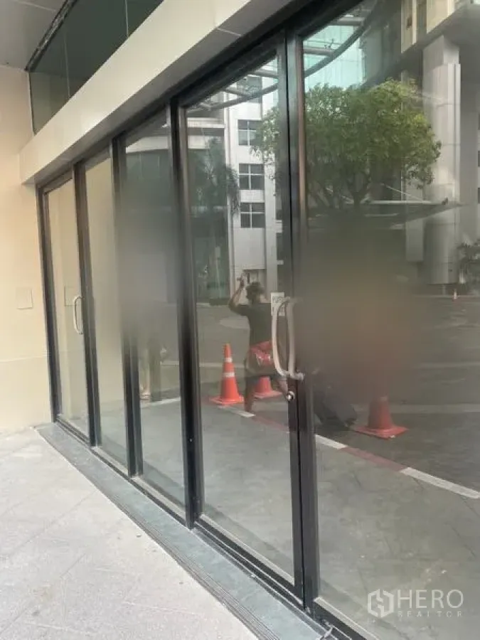 Retail Space for rent in Khlong Toei, Bangkok - Street-facing glass storefront with black aluminum frames and sliding doors.