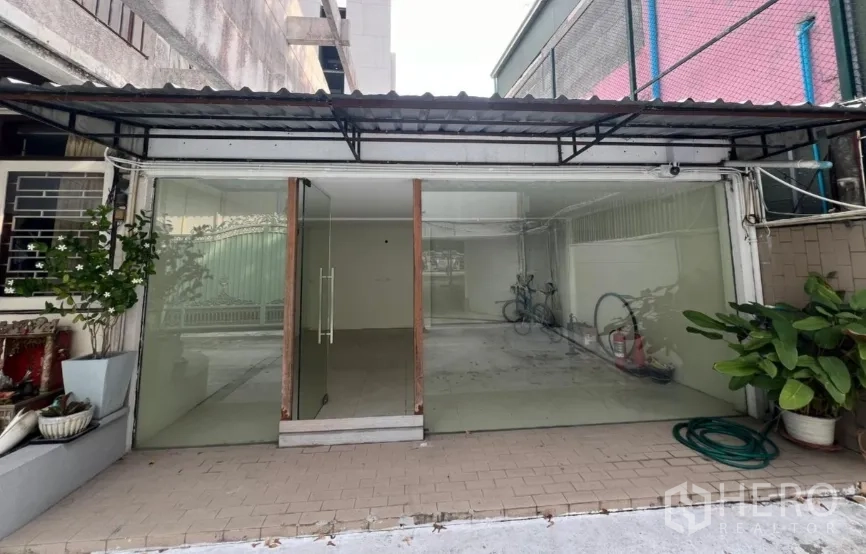 Retail Space for rent in Watthana, Bangkok - Front facade of single-storey retail space with large glass panels and potted plants.