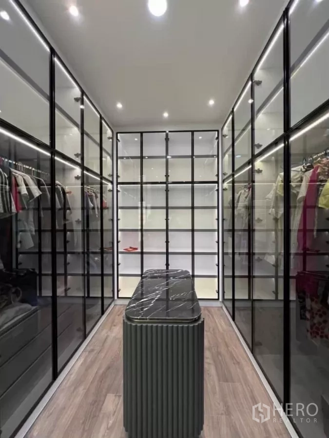 Detached House for rent in Phaya Thai, Bangkok - Walk-in closet with glass wardrobes, LED lighting and a central island bench.