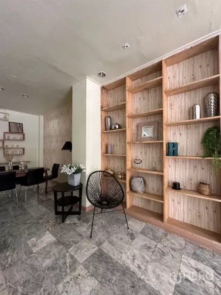 Home Office for rent in Suan Luang, Bangkok - Feature wall of wooden open shelving beside a seating area.