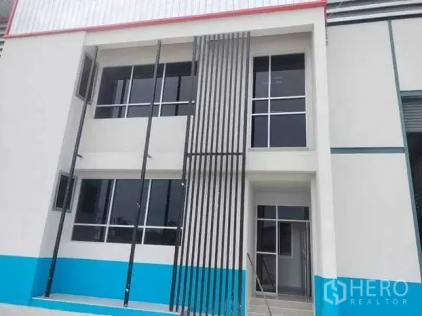 货栈 出租在Bang Phli, Samut Prakan - 现代两层仓库外立面，大面积窗户与竖向金属格栅。