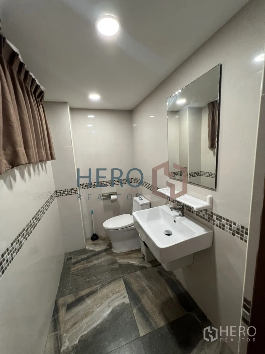 Detached House for rent in Watthana, Bangkok - Renovated bathroom with wall-hung sink, toilet and mosaic trim.