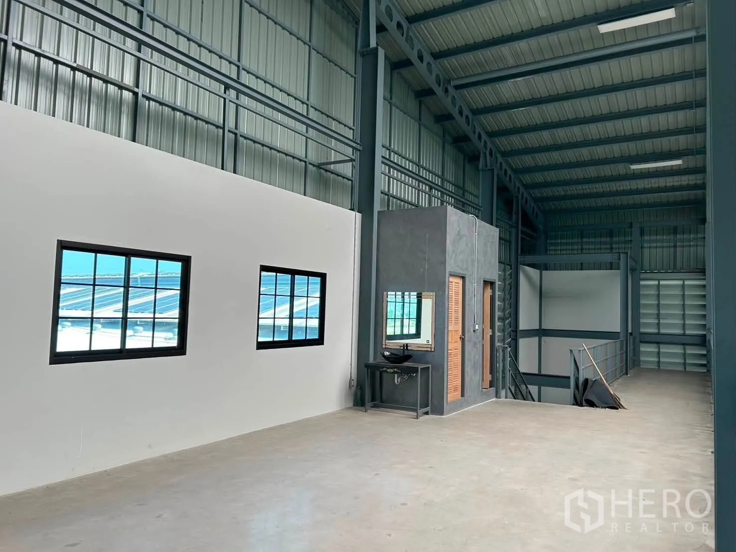 Warehouse for rent in Bang Phli, Samut Prakan - Upper-level office area with windows, a small built-in counter, and staircase access.