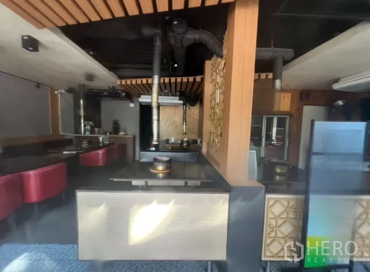 Retail Space for rent in Watthana, Bangkok - Dining-style layout with built-in tables, red booths, and ceiling exhaust ducts suited for a restaurant.