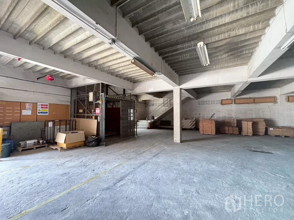 Factory for rent or sale in Bang Khun Thian, Bangkok - Spacious indoor storage zone with goods lift and staircase access.