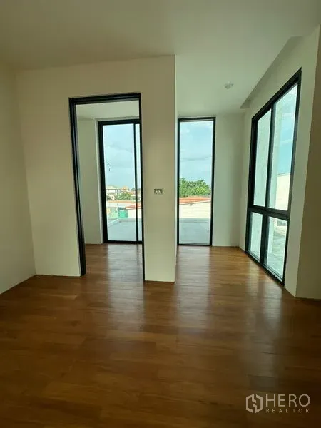 Detached House for rent in Watthana, Bangkok - Corner room with floor-to-ceiling windows and access to a large terrace, offering abundant natural light.