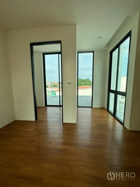 Detached House for rent in Watthana, Bangkok - Corner room with floor-to-ceiling windows and access to a large terrace, offering abundant natural light.
