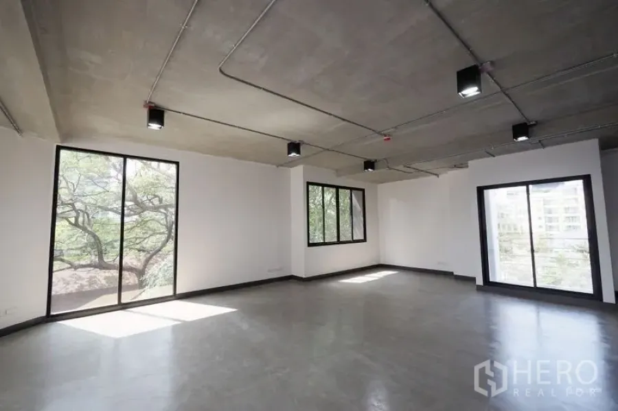 办公空间 出租在Watthana, Bangkok - 明亮转角办公室，三面大窗，外露灯具，自然采光充沛