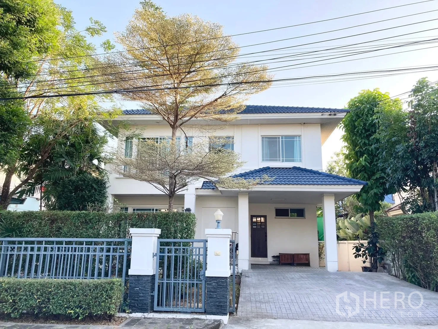 Detached House for rent in Prawet, Bangkok - Front exterior of two-storey detached house with gate, driveway and covered carport.
