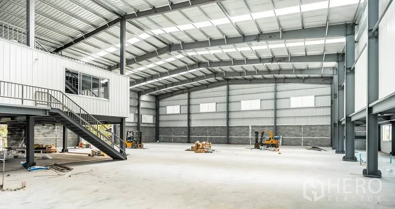Warehouse for rent in Lat Krabang, Bangkok - Open-plan warehouse floor with mezzanine office, high roof structure and natural light panels for efficient operations.
