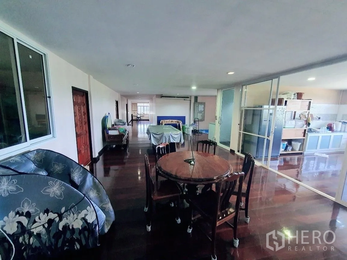 Warehouse for rent in Lam Luk Ka, Pathum Thani - Staff residence or office lounge with dining table, pantry and glossy wooden floors.