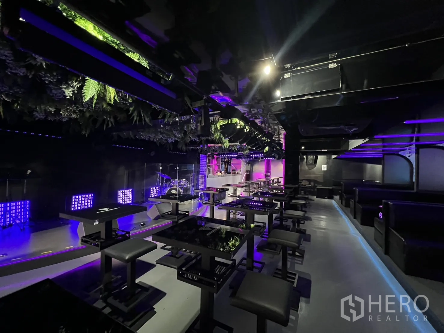 Retail Space for rent in Watthana, Bangkok - Stage with performance lighting, ceiling greenery and dining tables in an open plan.