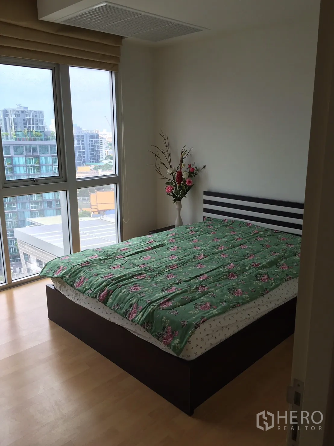 Condominium for rent or sale in Khlong Toei, Bangkok - Sunlit bedroom with a double bed, large windows and city view.