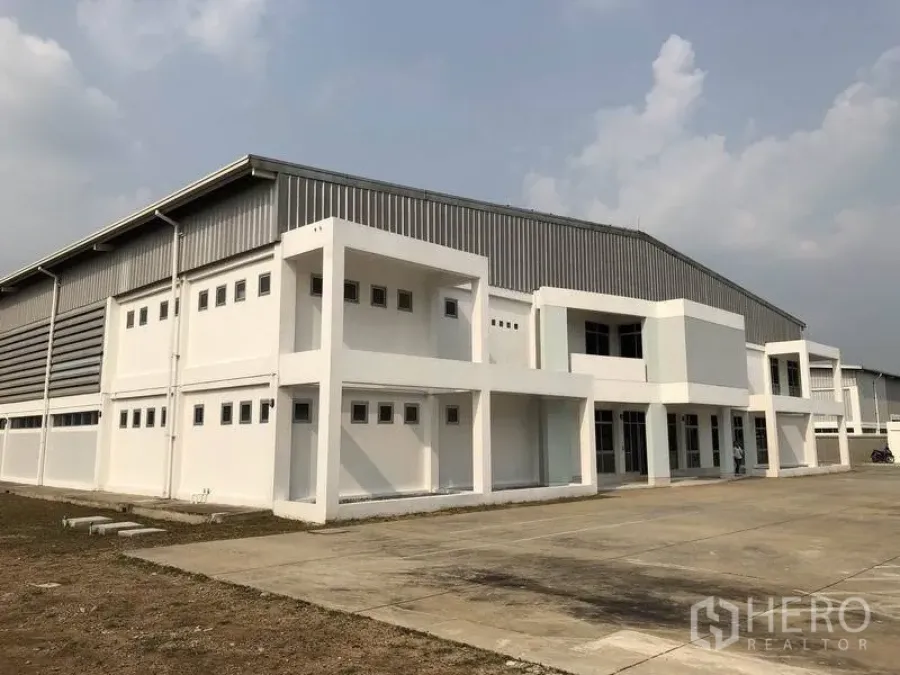 Factory for rent in Bang Pa-in, Phra Nakhon Si Ayutthaya - Modern factory exterior with two-storey office block and wide concrete yard in Bang Pa-in.