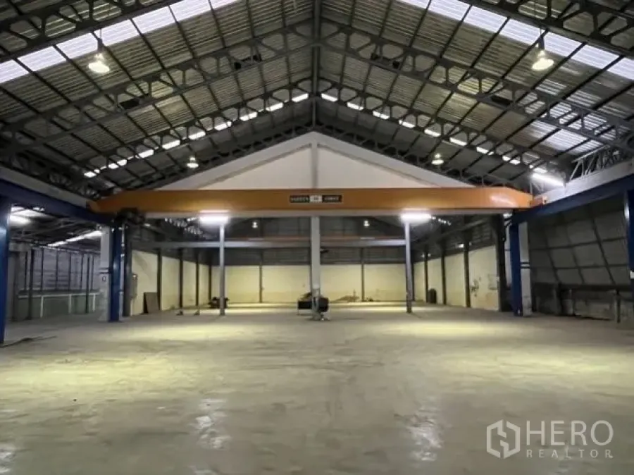 Factory for rent in Mueang Samut Sakhon, Samut Sakhon - Spacious factory interior with a high steel truss roof, bright lighting, and an overhead crane.