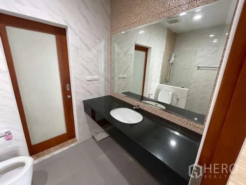 带办公室的家 出租或出售在Wang Thonglang, Bangkok - 卫浴长形黑色台面、下嵌式洗手盆与大镜子