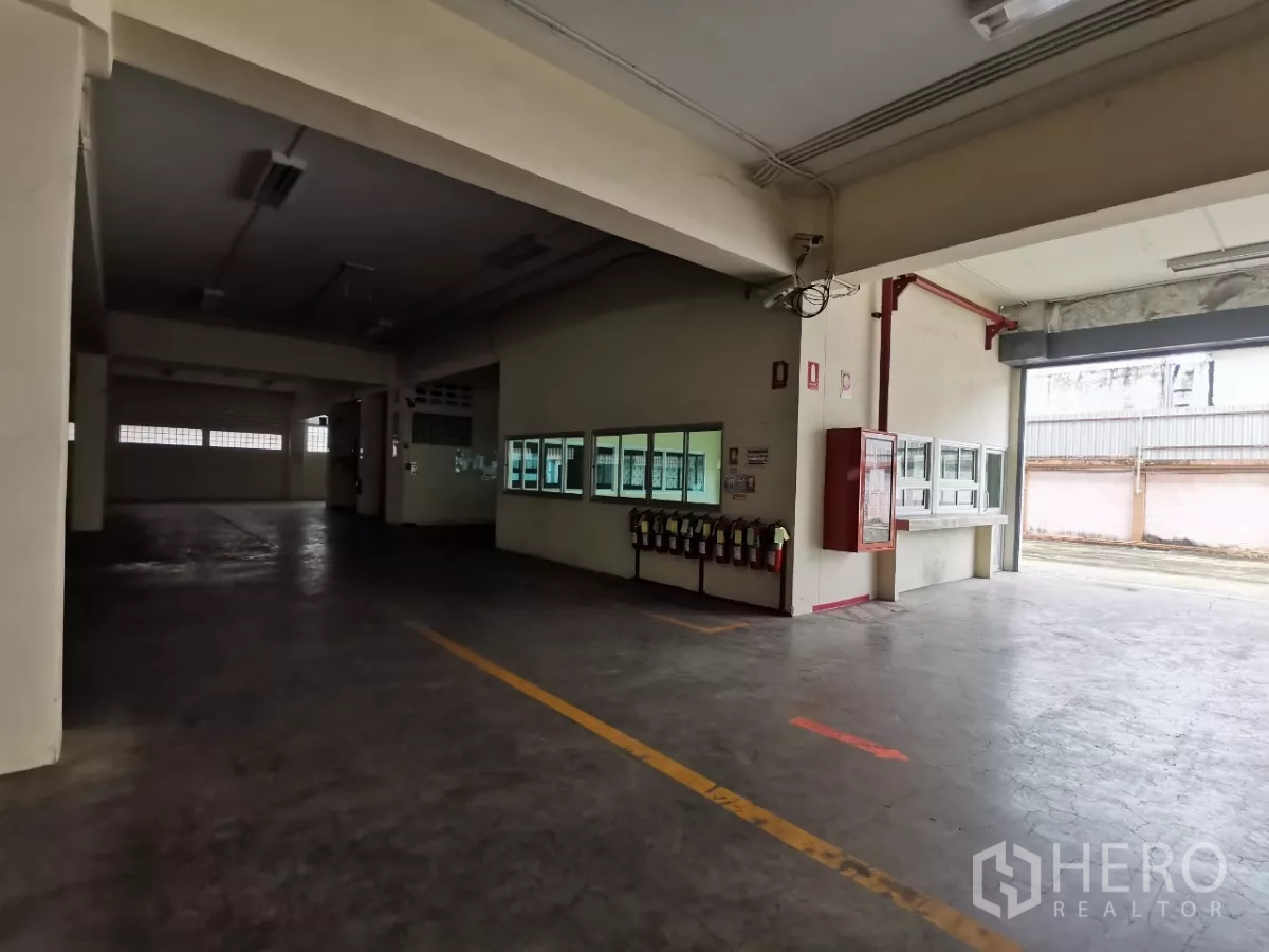 Factory for rent in Khlong Toei, Bangkok - Covered loading bay with roller shutter door and fire safety equipment.