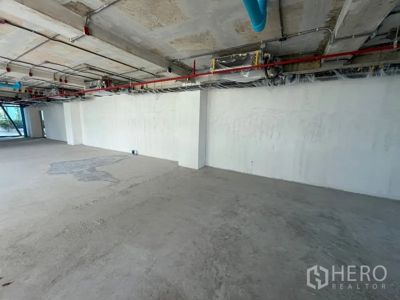 Retail Space for rent in Pathum Wan, Bangkok - Expansive raw space with concrete floor and exposed building services.