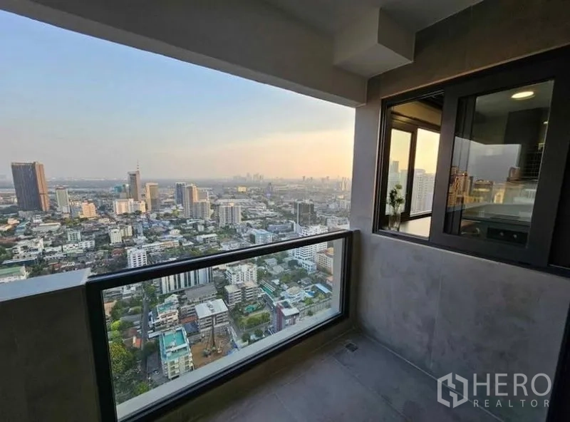 Condominium for rent or sale - Covered balcony with glass railing and far-reaching city views.