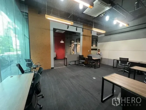 Office Space for rent - Spacious office with high ceilings, expansive glass frontage, modern lighting and a flexible desk layout.