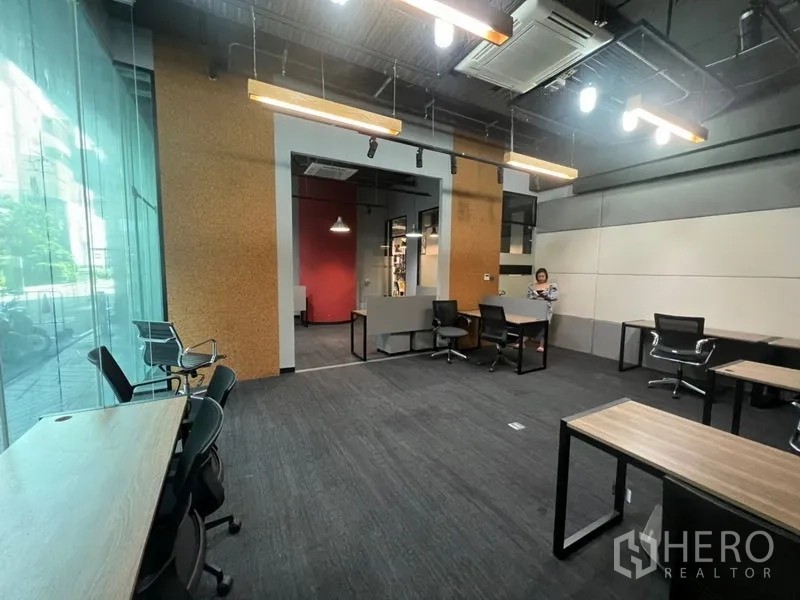 Office Space for rent - Spacious office with high ceilings, expansive glass frontage, modern lighting and a flexible desk layout.