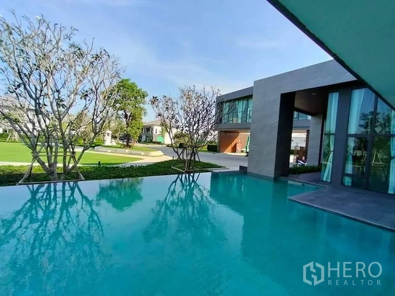 Detached House for sale in Bang Phli, Samut Prakan - Infinity‑edge swimming pool at the estate clubhouse overlooking gardens