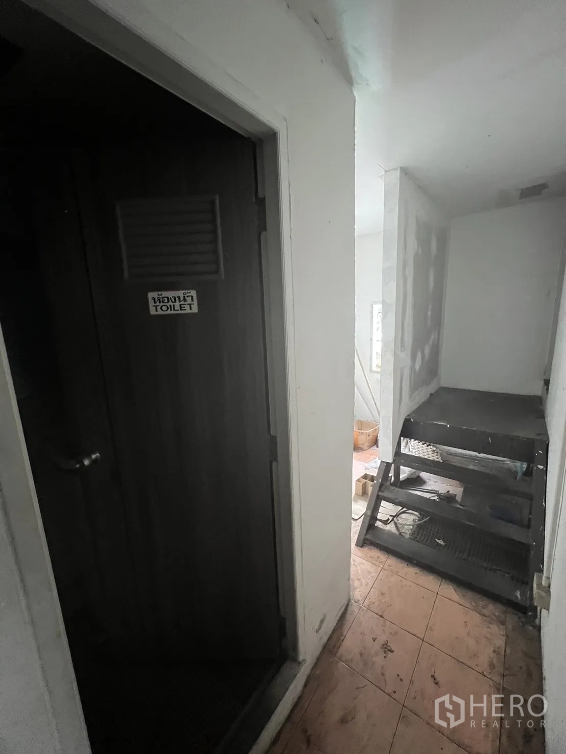 店屋 出租在Khlong Toei, Bangkok - 楼上走廊，一侧为厕所门，另一侧为金属服务楼梯。
