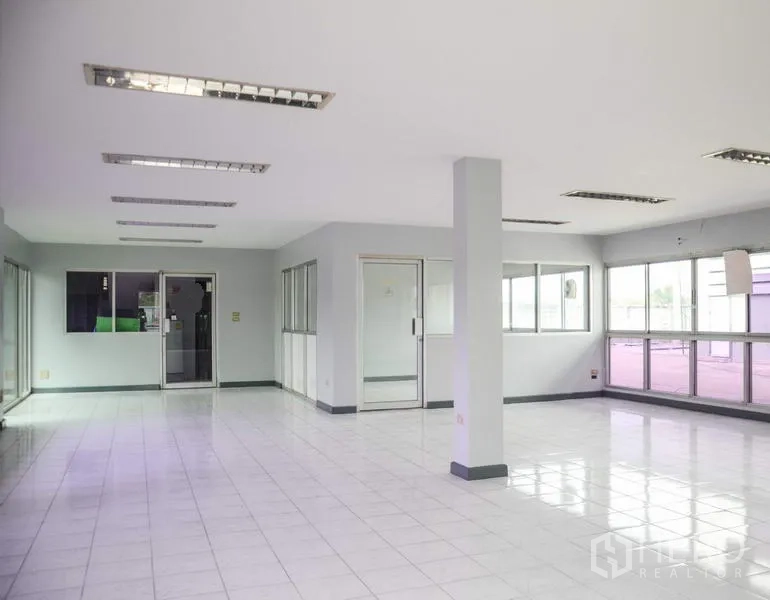 Factory for rent in Pathum Thani - Bright office interior with tiled floors, glass partitions, and fluorescent lighting.