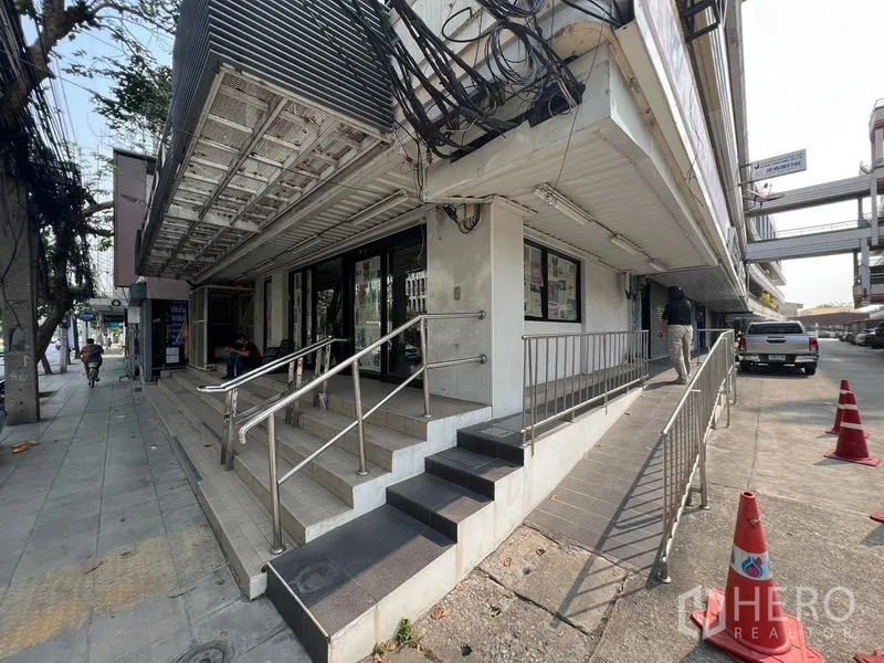 店屋 出租在Watthana, Bangkok - 商铺转角外立面，临人行道，设台阶与无障碍坡道。