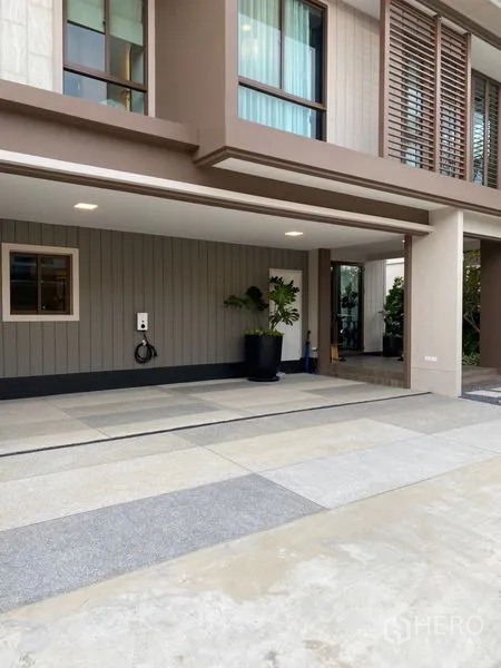Detached House for sale in Bang Kapi, Bangkok - Wide driveway and covered carport with EV charger outlet beside the main entrance.