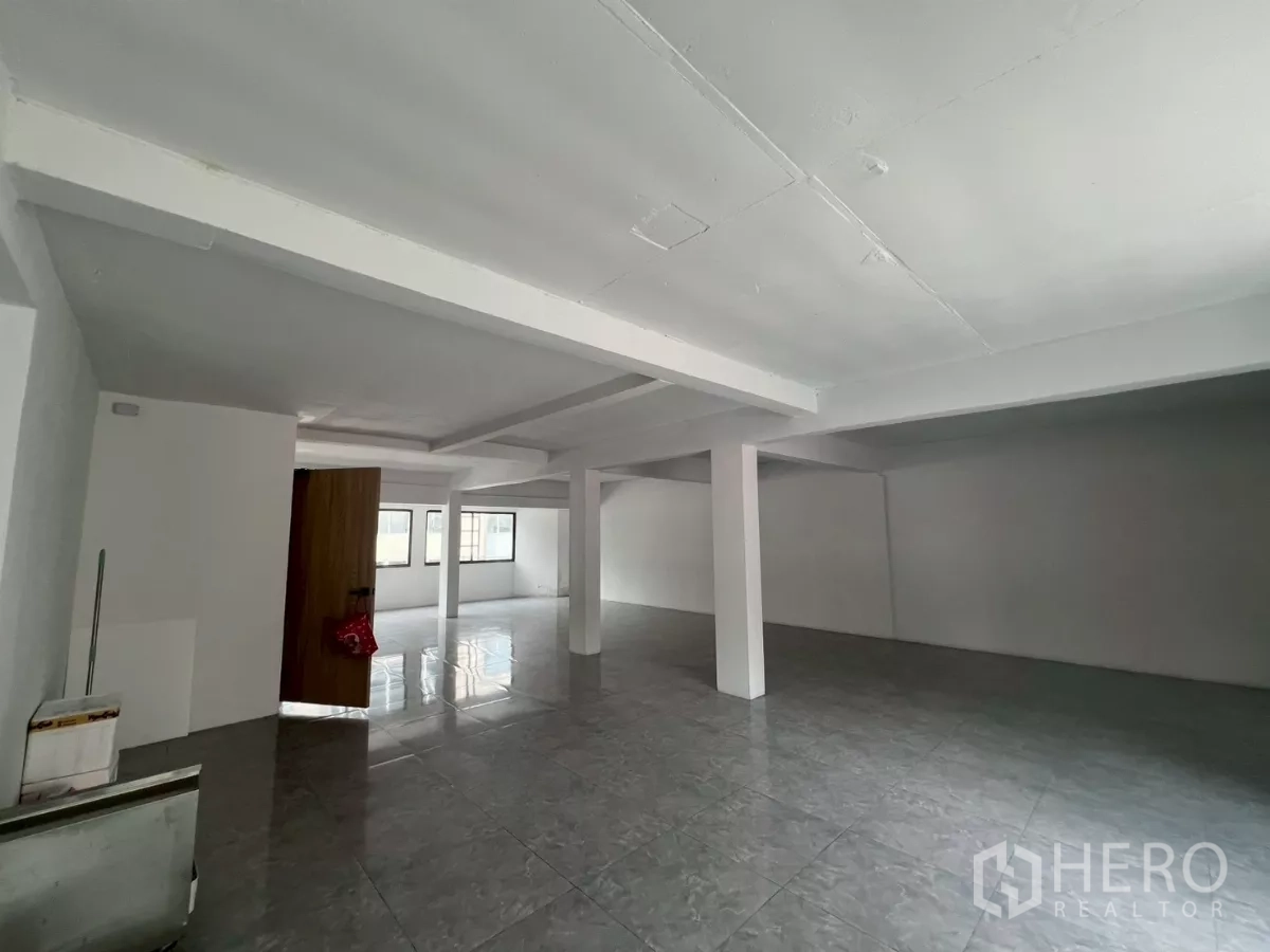Retail Space for rent in Pathum Wan, Bangkok - Open-plan level featuring structural columns and a wooden entry door.
