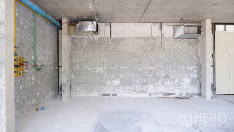 Retail Space for rent in Watthana, Bangkok - Service wall showing piping and ventilation in an unfinished commercial unit.