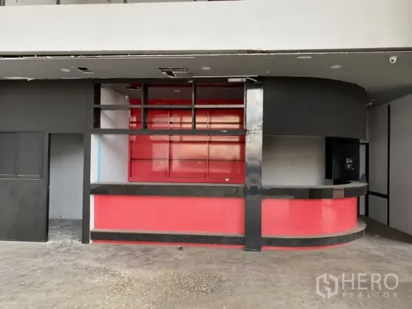 Showroom for rent in Lat Phrao, Bangkok - Ground-floor reception area featuring a red curved counter and open shelving.