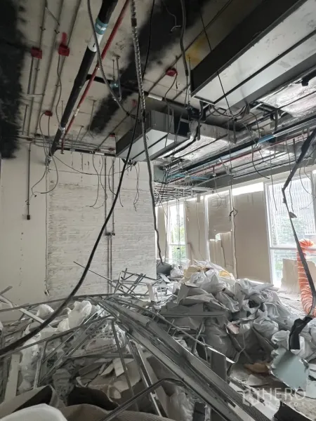 Retail Space for rent - Unfinished shop space showing hanging cables, air-conditioning ducts and metal studs.