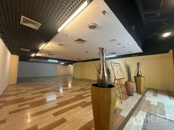 Retail Space for rent - Showroom zone with decorative vases and framed art beside a feature yellow wall.