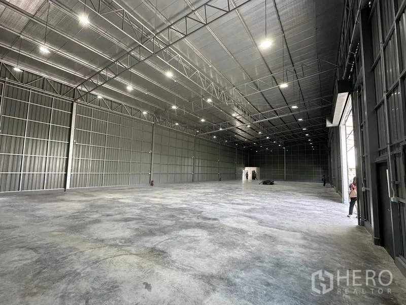 Warehouse for rent in Pak Kret, Nonthaburi - High-clear height warehouse showing insulated roof, steel framing and ample overhead lights.
